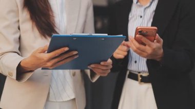 İş adamları modern ofisin önünde yürür ve birbirleriyle konuşurlar.