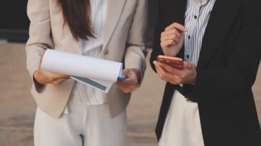 İş adamları modern ofisin önünde yürür ve birbirleriyle konuşurlar.