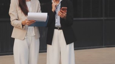 İş adamları modern ofisin önünde yürür ve birbirleriyle konuşurlar.