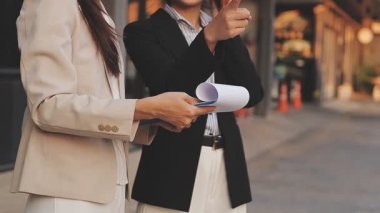 İş adamları modern ofisin önünde yürür ve birbirleriyle konuşurlar.