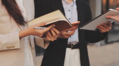 İş adamları modern ofisin önünde yürür ve birbirleriyle konuşurlar.