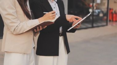 İş adamları modern ofisin önünde yürür ve birbirleriyle konuşurlar.