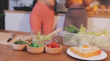 Kadın, sağlıklı yemek hazırlamak için mutfak tezgahında sebze kesiyor.