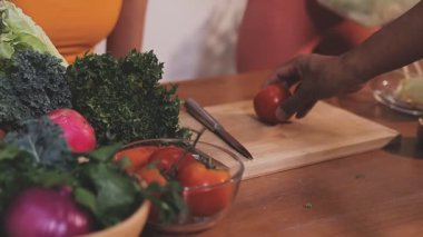 Kadın, sağlıklı yemek hazırlamak için mutfak tezgahında sebze kesiyor.