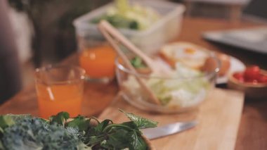 Kadın, sağlıklı yemek hazırlamak için mutfak tezgahında sebze kesiyor.