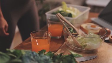 Kadın, sağlıklı yemek hazırlamak için mutfak tezgahında sebze kesiyor.