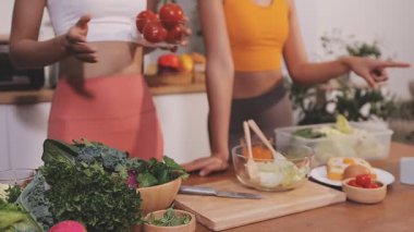 Kadın, sağlıklı yemek hazırlamak için mutfak tezgahında sebze kesiyor.
