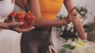 Kadın, sağlıklı yemek hazırlamak için mutfak tezgahında sebze kesiyor.