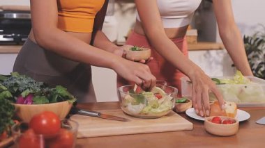 Kadın, sağlıklı yemek hazırlamak için mutfak tezgahında sebze kesiyor.