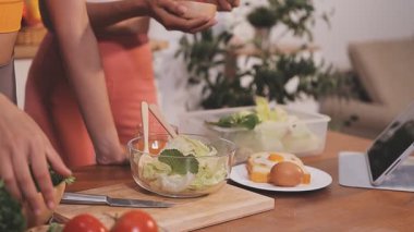 Kadın, sağlıklı yemek hazırlamak için mutfak tezgahında sebze kesiyor.