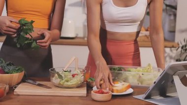 Kadın, sağlıklı yemek hazırlamak için mutfak tezgahında sebze kesiyor.