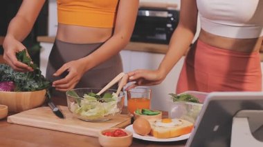 Kadın, sağlıklı yemek hazırlamak için mutfak tezgahında sebze kesiyor.