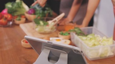 Kadın, sağlıklı yemek hazırlamak için mutfak tezgahında sebze kesiyor.