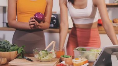 Kadın, sağlıklı yemek hazırlamak için mutfak tezgahında sebze kesiyor.