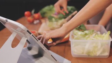 Kadın, sağlıklı yemek hazırlamak için mutfak tezgahında sebze kesiyor.