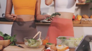 Kadın, sağlıklı yemek hazırlamak için mutfak tezgahında sebze kesiyor.