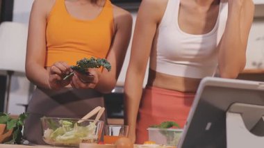 Kadın, sağlıklı yemek hazırlamak için mutfak tezgahında sebze kesiyor.