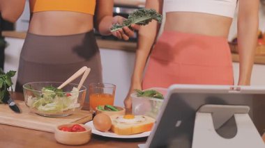 Kadın, sağlıklı yemek hazırlamak için mutfak tezgahında sebze kesiyor.