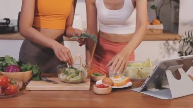 Kadın, sağlıklı yemek hazırlamak için mutfak tezgahında sebze kesiyor.