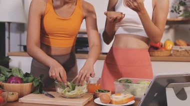 Kadın, sağlıklı yemek hazırlamak için mutfak tezgahında sebze kesiyor.