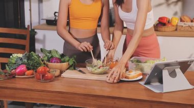 Kadın, sağlıklı yemek hazırlamak için mutfak tezgahında sebze kesiyor.
