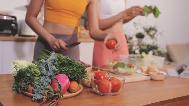 Kadın, sağlıklı yemek hazırlamak için mutfak tezgahında sebze kesiyor.