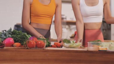 Kadın, sağlıklı yemek hazırlamak için mutfak tezgahında sebze kesiyor.