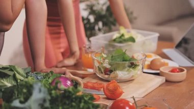 Kadın, sağlıklı yemek hazırlamak için mutfak tezgahında sebze kesiyor.
