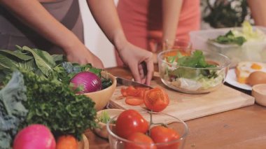 Kadın, sağlıklı yemek hazırlamak için mutfak tezgahında sebze kesiyor.