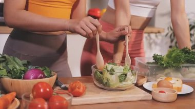 Kadın, sağlıklı yemek hazırlamak için mutfak tezgahında sebze kesiyor.