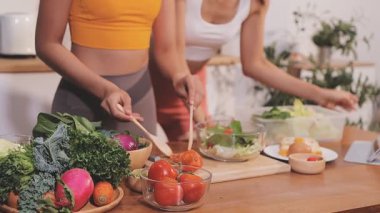 Kadın, sağlıklı yemek hazırlamak için mutfak tezgahında sebze kesiyor.