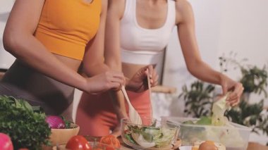 Kadın, sağlıklı yemek hazırlamak için mutfak tezgahında sebze kesiyor.