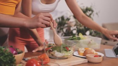 Kadın, sağlıklı yemek hazırlamak için mutfak tezgahında sebze kesiyor.