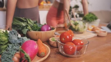Kadın, sağlıklı yemek hazırlamak için mutfak tezgahında sebze kesiyor.