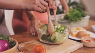Kadın, sağlıklı yemek hazırlamak için mutfak tezgahında sebze kesiyor.