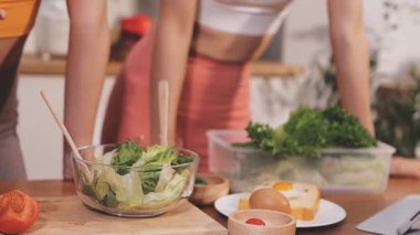 Kadın, sağlıklı yemek hazırlamak için mutfak tezgahında sebze kesiyor.