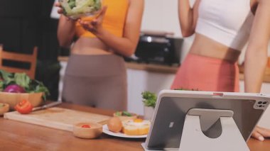 Kadın, sağlıklı yemek hazırlamak için mutfak tezgahında sebze kesiyor.