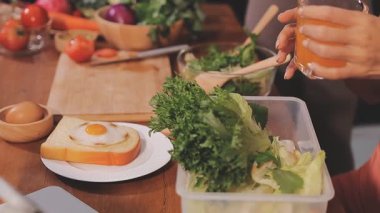 Kadın, sağlıklı yemek hazırlamak için mutfak tezgahında sebze kesiyor.