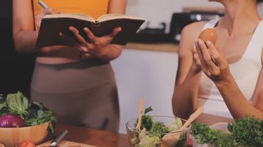 Kadın, sağlıklı yemek hazırlamak için mutfak tezgahında sebze kesiyor.