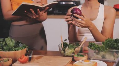 Kadın, sağlıklı yemek hazırlamak için mutfak tezgahında sebze kesiyor.