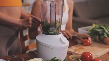 Kadın, sağlıklı yemek hazırlamak için mutfak tezgahında sebze kesiyor.