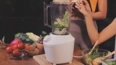 Kadın, sağlıklı yemek hazırlamak için mutfak tezgahında sebze kesiyor.