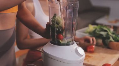 Kadın, sağlıklı yemek hazırlamak için mutfak tezgahında sebze kesiyor.