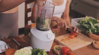 Kadın, sağlıklı yemek hazırlamak için mutfak tezgahında sebze kesiyor.