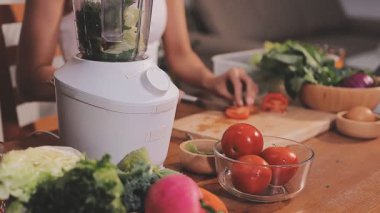 Kadın, sağlıklı yemek hazırlamak için mutfak tezgahında sebze kesiyor.