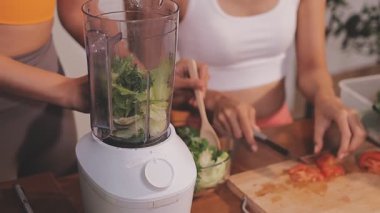 Kadın, sağlıklı yemek hazırlamak için mutfak tezgahında sebze kesiyor.