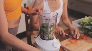 Kadın, sağlıklı yemek hazırlamak için mutfak tezgahında sebze kesiyor.