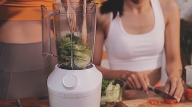 Kadın, sağlıklı yemek hazırlamak için mutfak tezgahında sebze kesiyor.
