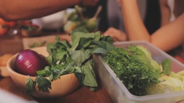 Kadın, sağlıklı yemek hazırlamak için mutfak tezgahında sebze kesiyor.