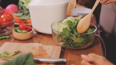 Kadın, sağlıklı yemek hazırlamak için mutfak tezgahında sebze kesiyor.